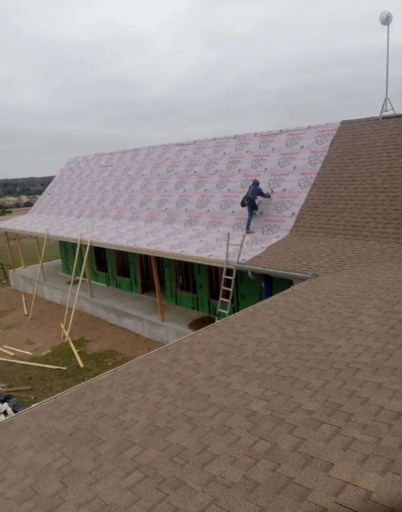 Worker preparing underlayment for a metal roof installation in Upper St. Clair